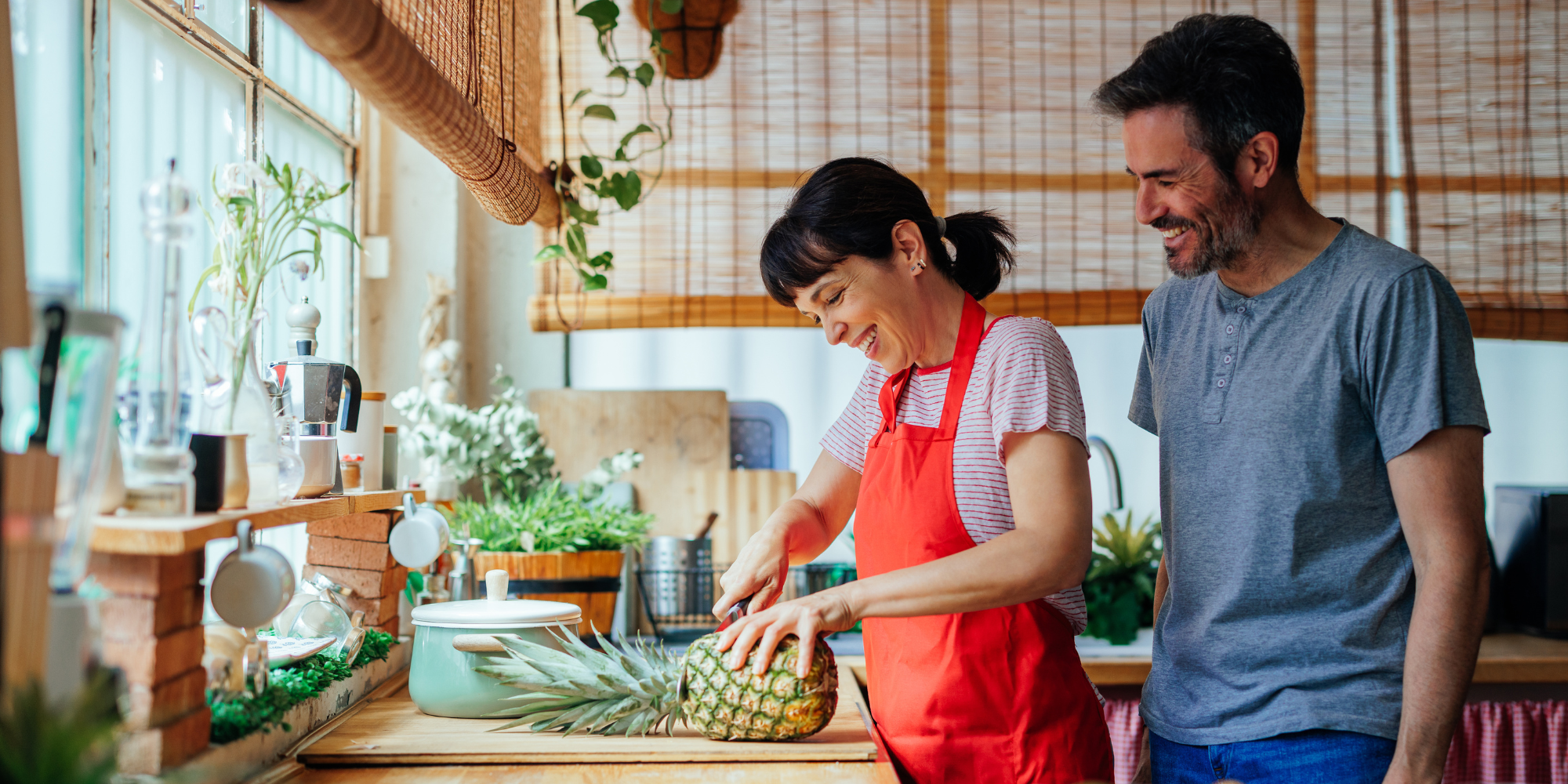 A husband and wife exhibiting good communication skills while cooking together.