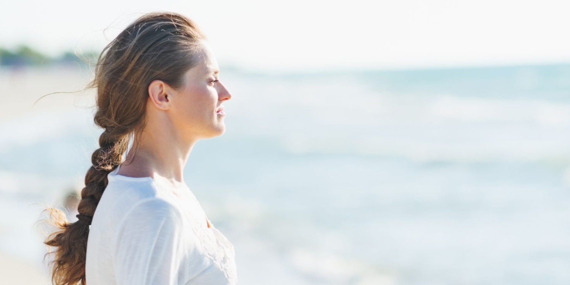 A woman looking out on the ocean, representing the five stages of grief.