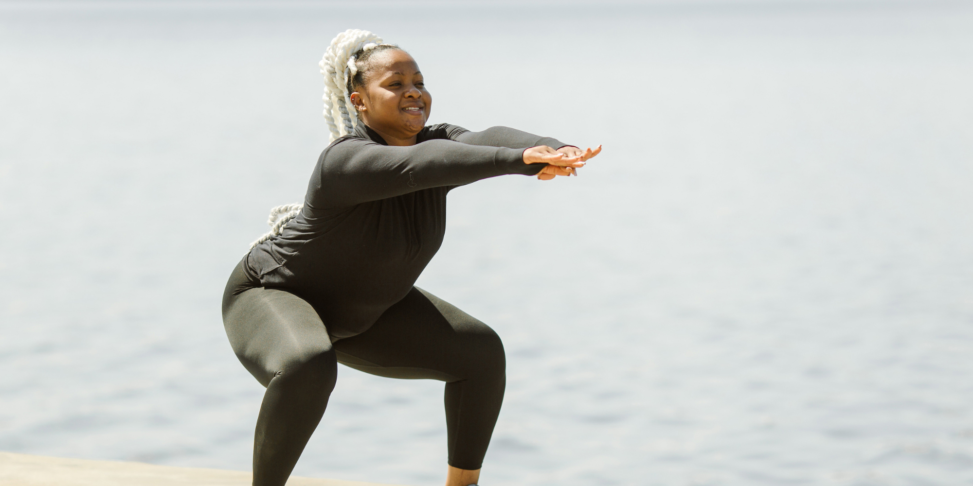 A woman exercising next to water to benefit her mental health.