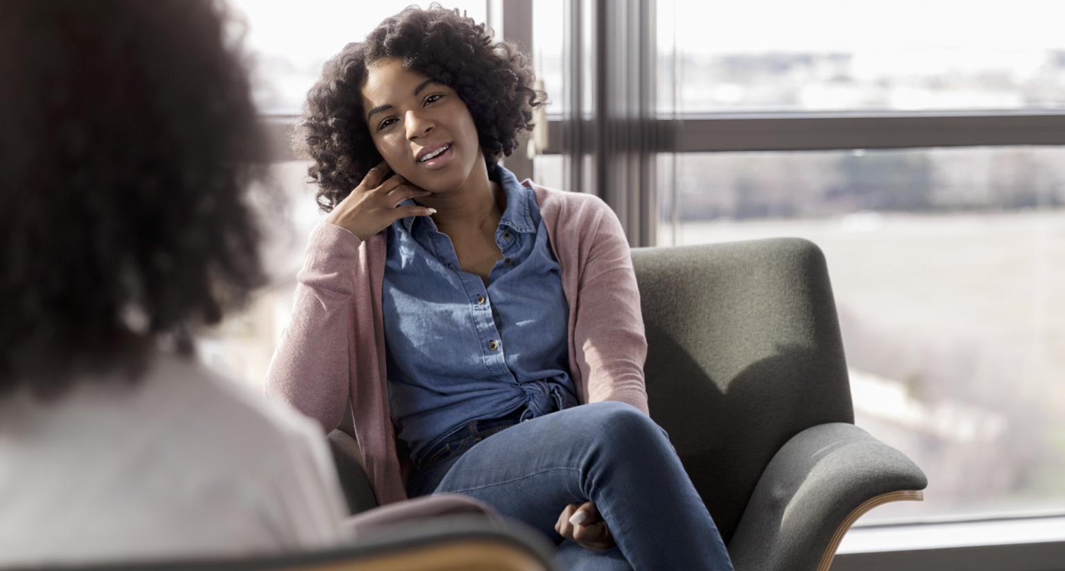 A woman talking to her therapist about online or in-person therapy.