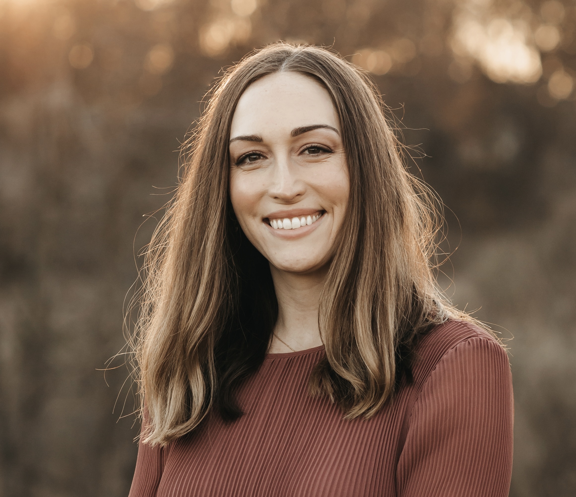 Chelsea Buzzitta smiling at the camera in an outdoor setting.