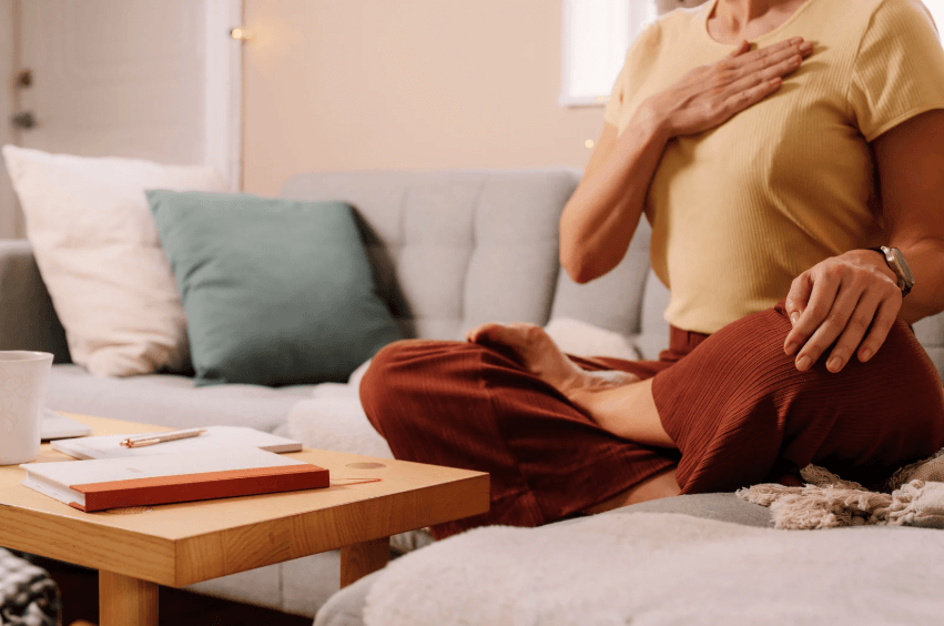 Woman indoors relaxing and meditating while doing breathing exercises.